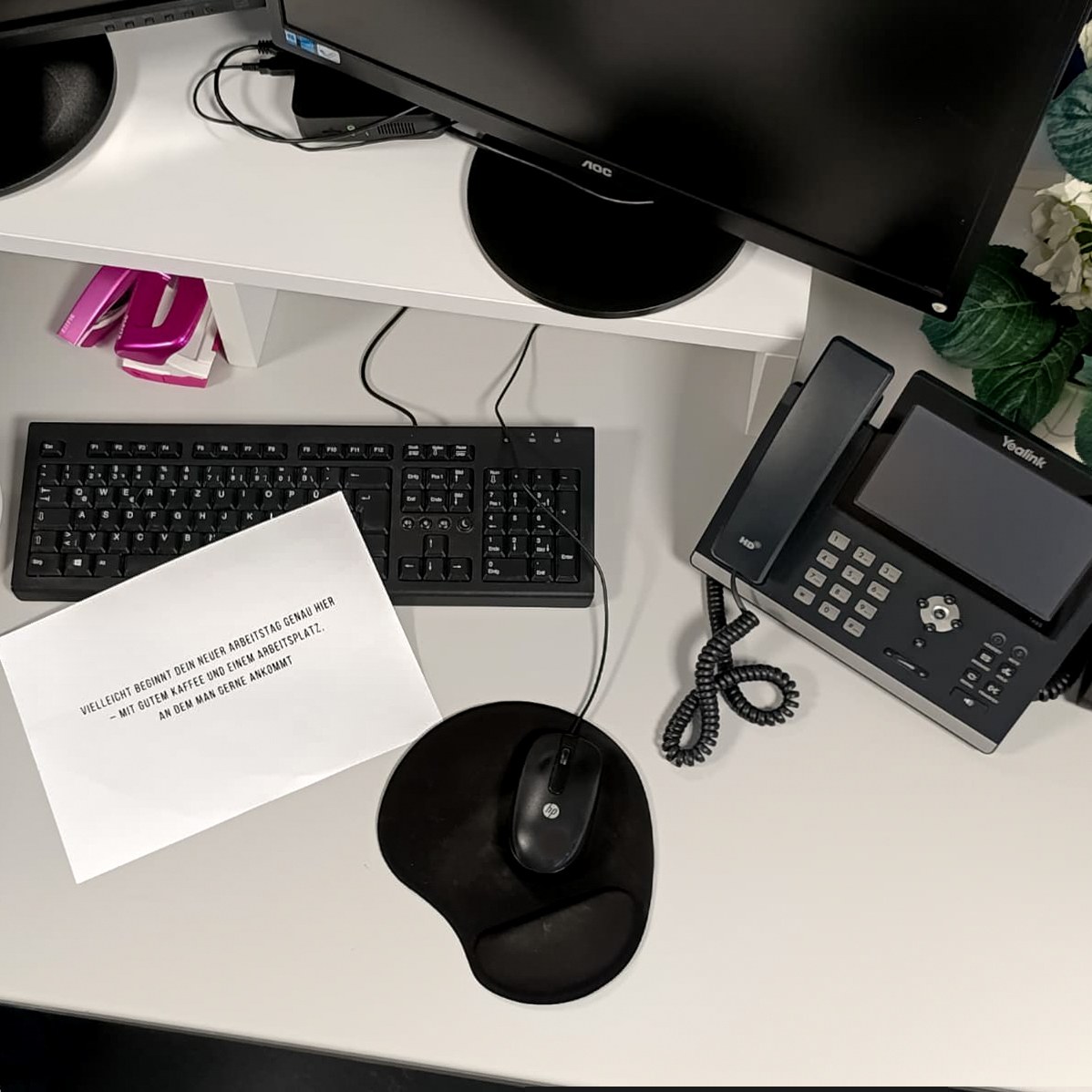 Arbeitsplatz mit Telefon, Tastatur und Notizkarte